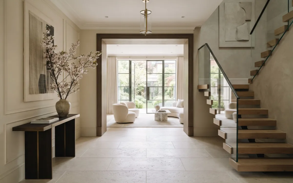 Contemporary elegant entryway with an architectural doorway, sculptural staircase, and balanced natural finishes.