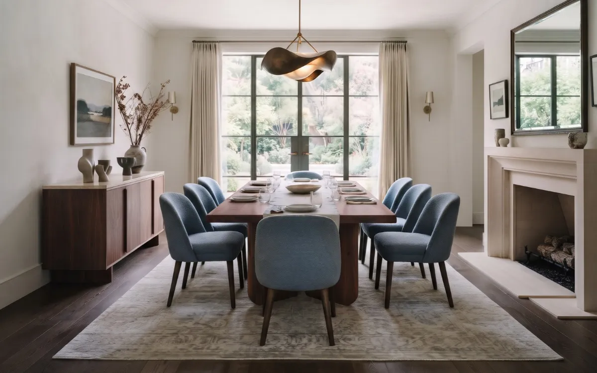 Timeless dining room with a walnut table, upholstered chairs, layered lighting, and coordinated natural materials.