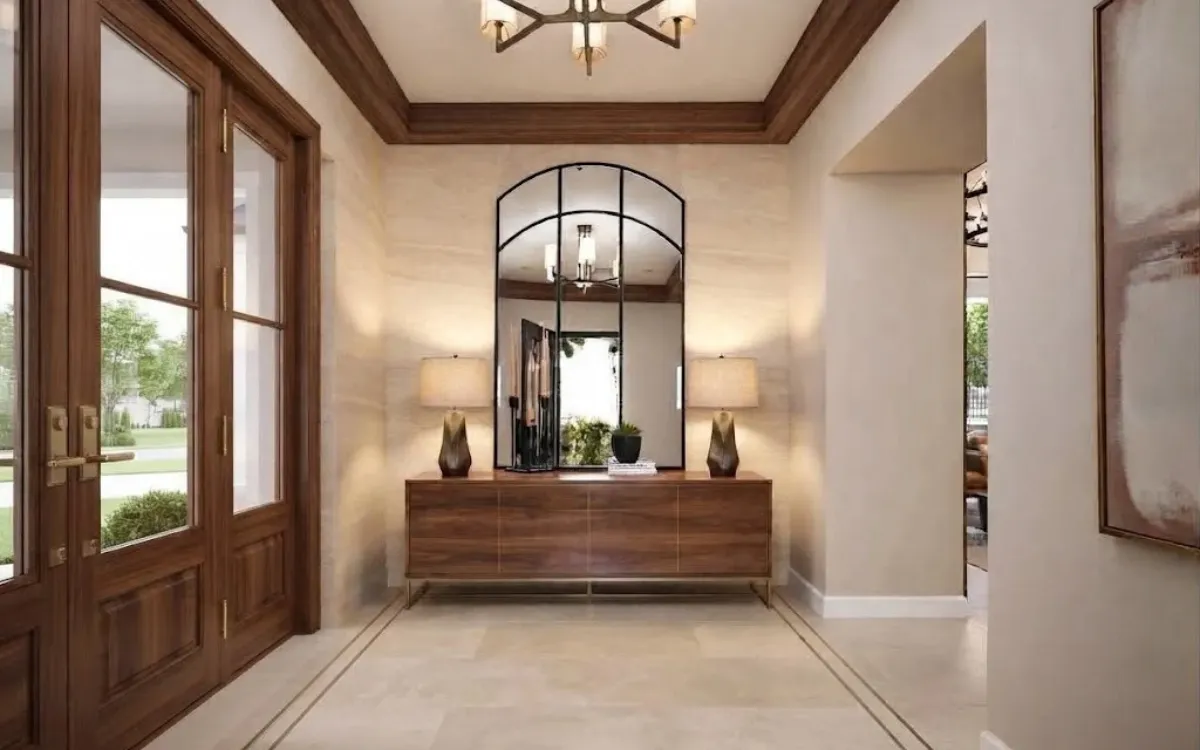 A refined residential entryway with a natural wood console, framed mirror, restrained accessories and complementary architectural finishes.